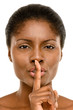 Cute African American woman finger on lips isolated on white bac