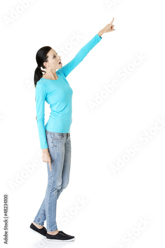 Photo: Happy , excited young woman pointing on copy space Happy , excited young woman pointing on copy space