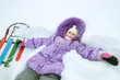 Little girl lying in deep snow