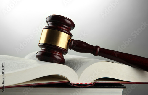 Photo: wooden gavel and books, on grey background wooden gavel and books, on grey background