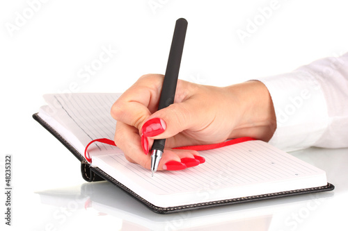 Photo: Hand signing in notebook isolated on white Hand signing in notebook isolated on white