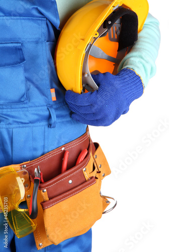 Photo: Male builder in blue overalls with yellow helmet isolated Male builder in blue overalls with yellow helmet isolated