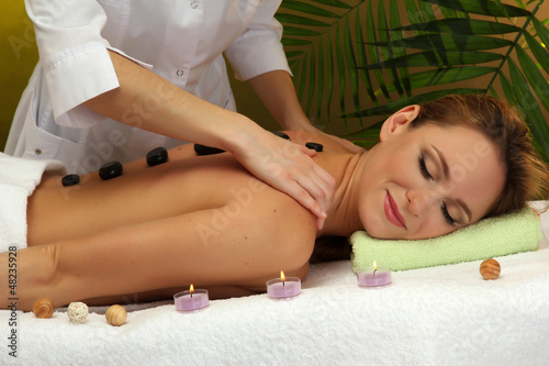 Photo: beautiful young woman in spa salon getting massage with spa beautiful young woman in spa salon getting massage with spa