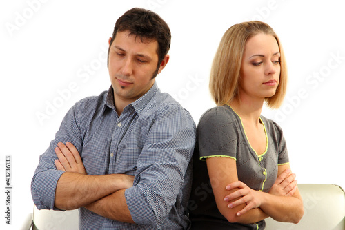 Photo: Young couple turning away from each other isolated on white Young couple turning away from each other isolated on white