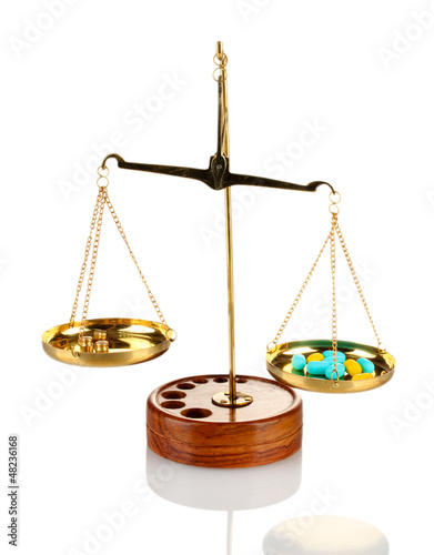 Photo: Classic scales with color pills isolated on white Classic scales with color pills isolated on white