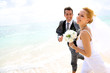 Just married couple running on a sandy beach