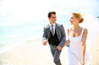 Just married couple running on a sandy beach