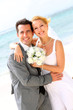 Photo: Cheerful married couple standing on the beach Cheerful married couple standing on the beach