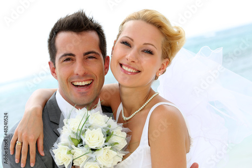 Photo: Cheerful married couple standing on the beach Cheerful married couple standing on the beach