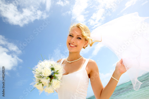 Photo: Portrait of beautiful bride with blue sky in background Portrait of beautiful bride with blue sky in background