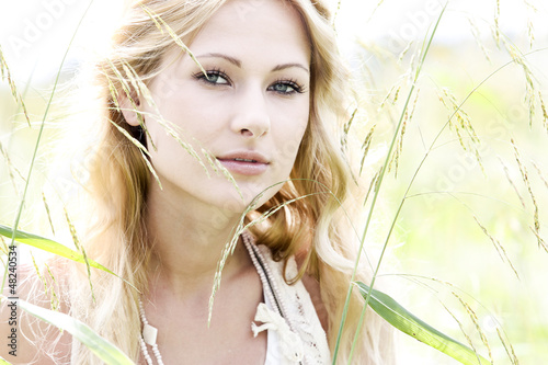 Photo: Glamorous young woman standing in meadow Glamorous young woman standing in meadow