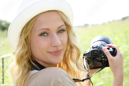 Photo: Portrait of adventure girl using photo camera in nature Portrait of adventure girl using photo camera in nature