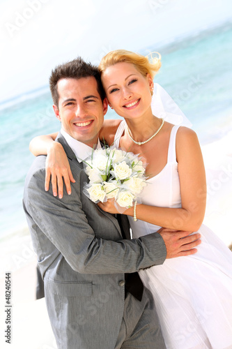 Photo: Cheerful married couple standing on the beach Cheerful married couple standing on the beach
