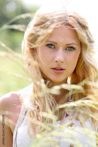 Photo: Beautiful blond girl in meadow Beautiful blond girl in meadow