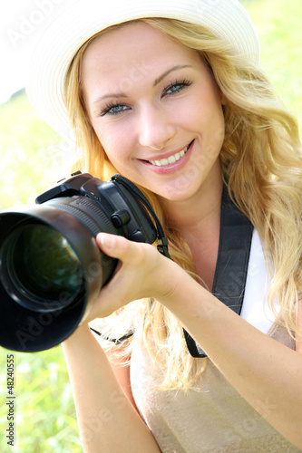 Photo: Portrait of adventure girl using photo camera in nature Portrait of adventure girl using photo camera in nature