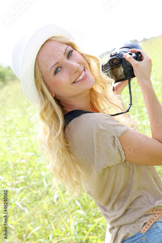Photo: Portrait of adventure girl using photo camera in nature Portrait of adventure girl using photo camera in nature