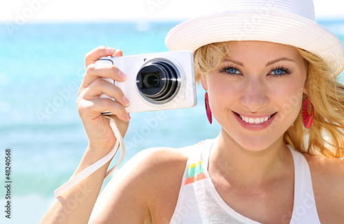 Photo: Cheerful girl talking pictures with digital camera Cheerful girl talking pictures with digital camera