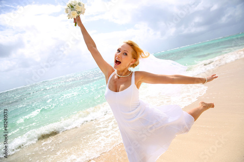 Photo: Cheerful bride showing happiness at the beach Cheerful bride showing happiness at the beach
