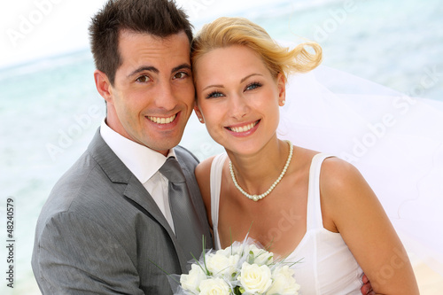 Photo: Cheerful married couple standing on the beach Cheerful married couple standing on the beach