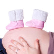 Photo: Neugeborenenschuhe auf Babybauch Neugeborenenschuhe auf Babybauch