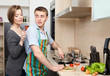 Man in apron slices vegetables for dinner for his girlfriend 