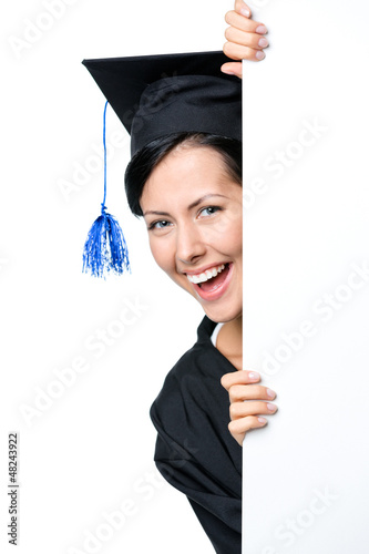 Photo: Graduating student peeps out from behind the copyspace, isolated Graduating student peeps out from behind the copyspace, isolated