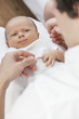 Father Holding Young Smiling Baby Hands