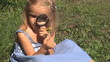 Child Looking at a Dandelion with a Magnifier
