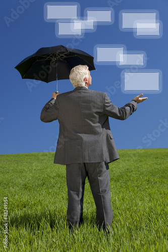 Photo: Businessman In Green Field Umbrella & Screens Businessman In Green Field Umbrella & Screens