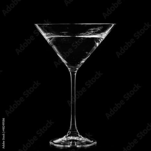 Photo: Martini in a cocktail glass isolated on black background Martini in a cocktail glass isolated on black background