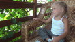 Child Laughing and Resting on a Straw Chair, Smiling Little Girl