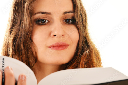 Photo: Young woman reading a book isolated on white Young woman reading a book isolated on white