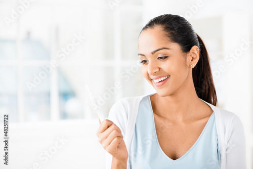Photo: Happy Indian woman taking pregancy test Happy Indian woman taking pregancy test