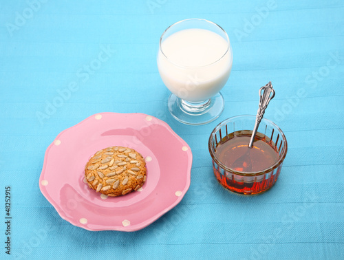 Photo: pink plate with sunflower seed cookie with honey and milk pink plate with sunflower seed cookie with honey and milk
