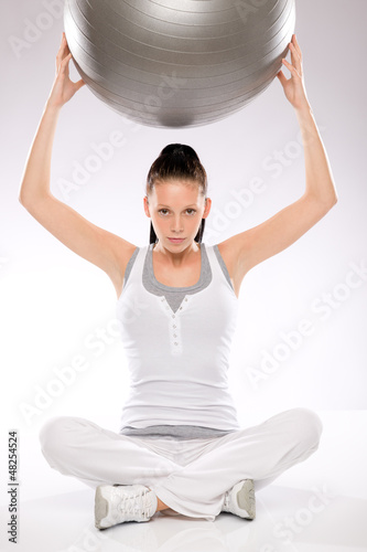Photo: Woman holding fitness ball above her head Woman holding fitness ball above her head