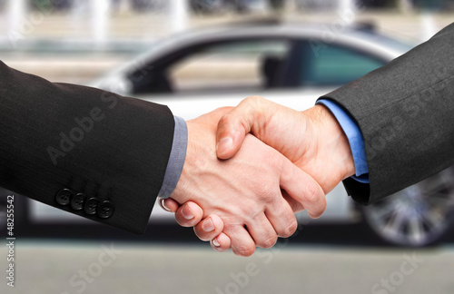 Photo: Two men shaking hands after a successful car purchase Two men shaking hands after a successful car purchase