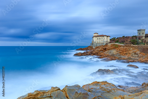 Photo: Boccale castle landmark on cliff rock and sea. Tuscany, Italy. Boccale castle landmark on cliff rock and sea. Tuscany, Italy.