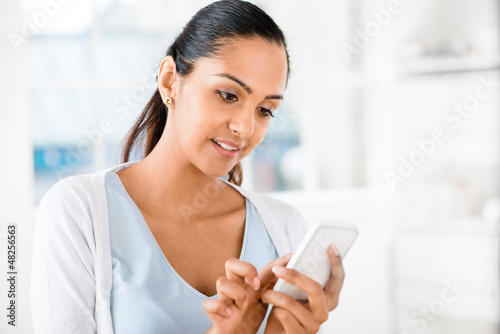 Photo: Beautiful Indian woman sending text message mobile phone happy Beautiful Indian woman sending text message mobile phone happy