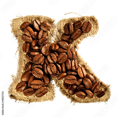 Photo: Alphabet from coffee beans on fabric texture isolated on white Alphabet from coffee beans on fabric texture isolated on white