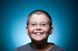 Foto: A portrait of a young boy with glasses smiling A portrait of a young boy with glasses smiling