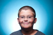Foto: A portrait of a young boy with glasses smiling A portrait of a young boy with glasses smiling