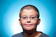 Foto: A portrait of a young boy with glasses smiling A portrait of a young boy with glasses smiling