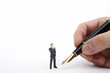 Photo: Businessman figurine looking hand holding a fountain pen Businessman figurine looking hand holding a fountain pen