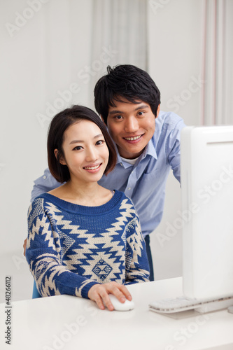 Photo: Young Asian couple using PC Young Asian couple using PC