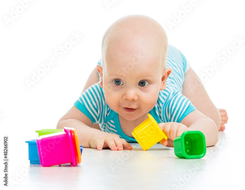 Photo: Funny little child is playing with toys isolated over white Funny little child is playing with toys isolated over white