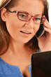 Young businesswoman using mobile phone and laptop