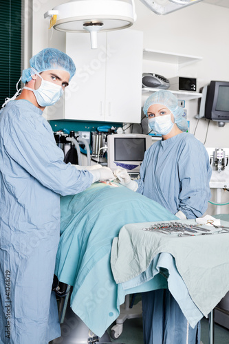 Photo: Veterinarian Doctor And Female Assistant Performing A Surgery Veterinarian Doctor And Female Assistant Performing A Surgery