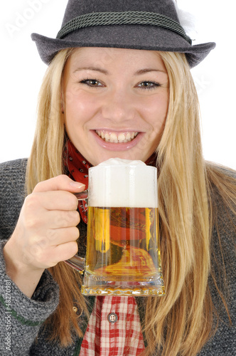 Photo: Junge Frau in bayrischer Kleidung trinkt Bier Junge Frau in bayrischer Kleidung trinkt Bier