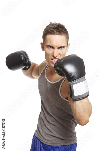 Photo: Muscular young man boxing in sports outfit Muscular young man boxing in sports outfit