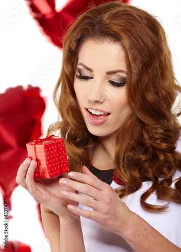 Photo: Valentine's Day. Beautiful smiling woman with a gift Valentine's Day. Beautiful smiling woman with a gift